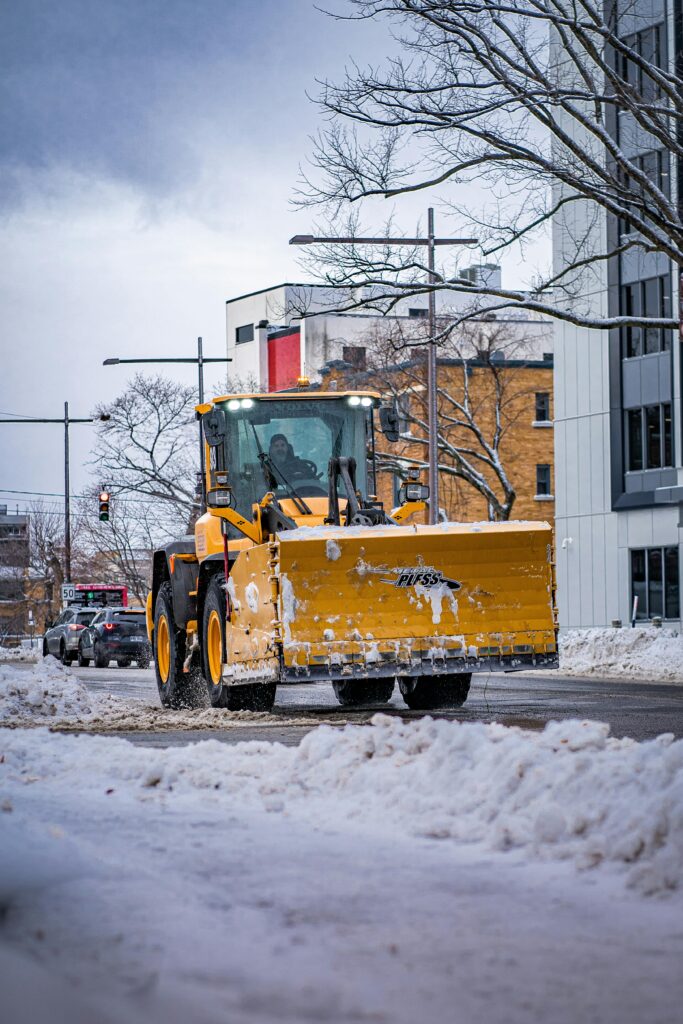 Snow plow truck clearing a snowy street in Québec, Canada, during winter.